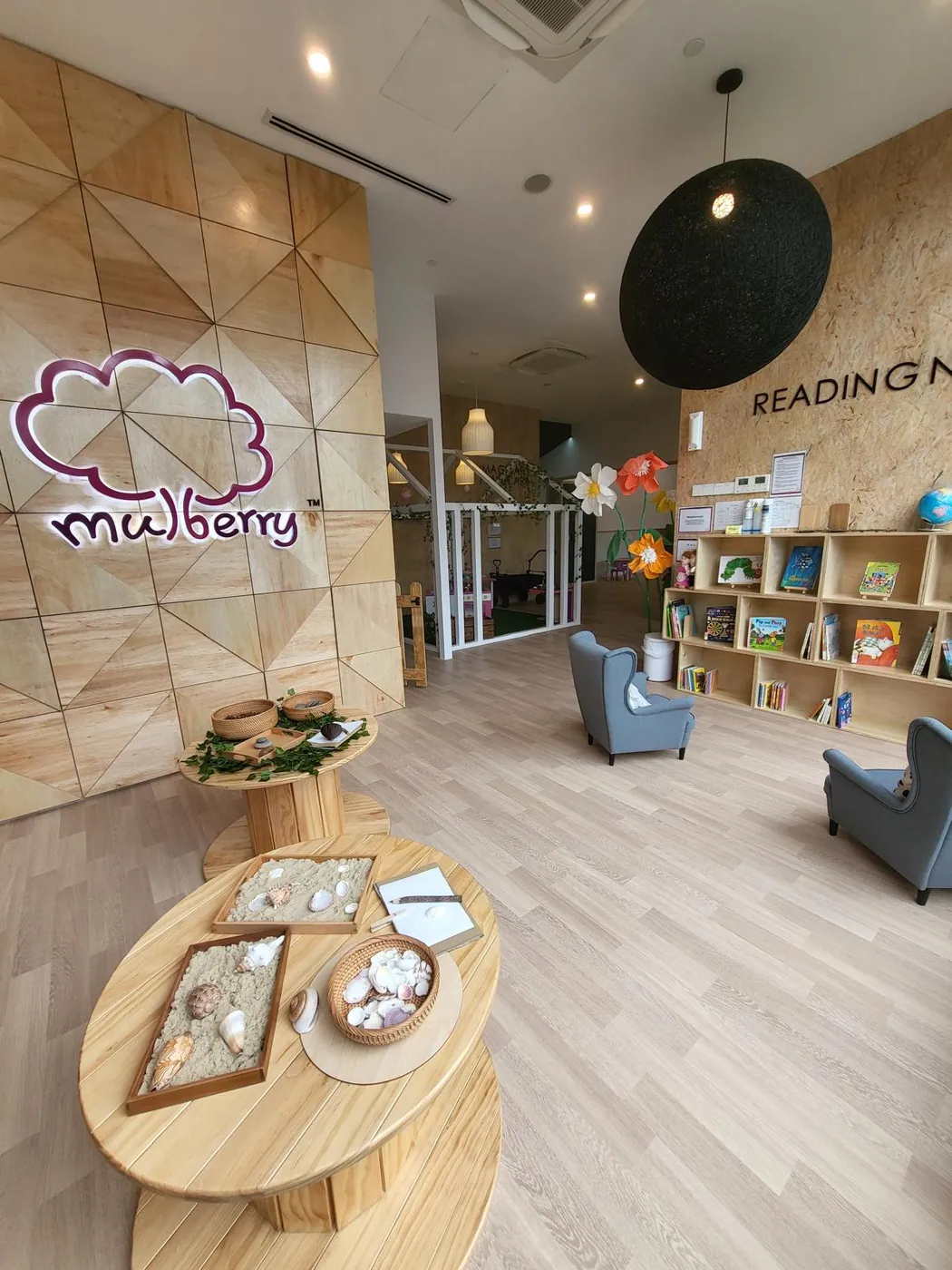 The Mulberry reception with its glowing cloud logo, reading nook and cosy armchairs